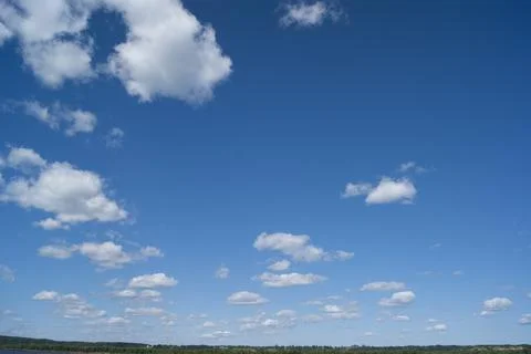 A blue sky with white fluffy clouds. Background, screensaver. Summer. Cloudy Stock Photos
