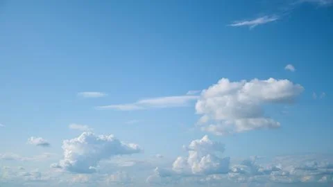 Blue sky with white fluffy clouds. Bright sunny day with clear atmosphere and Stock-Fotos