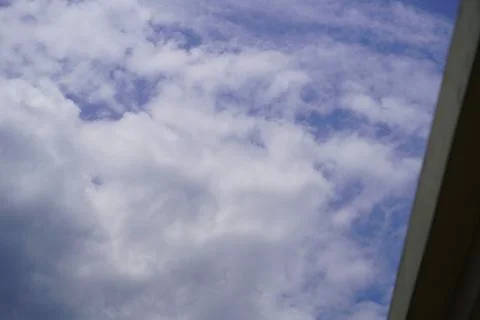 Blue sky with white fluffy clouds viewed from a low angle perspective Stock Photos
