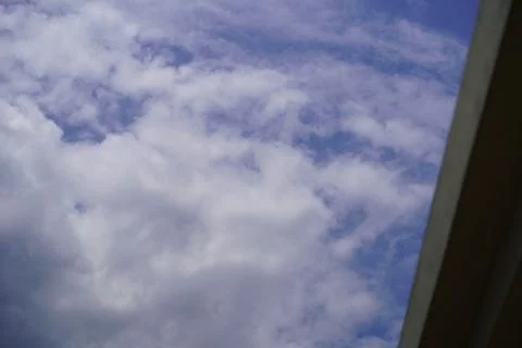 Blue sky with white fluffy clouds viewed from a low angle perspective Stock Photos