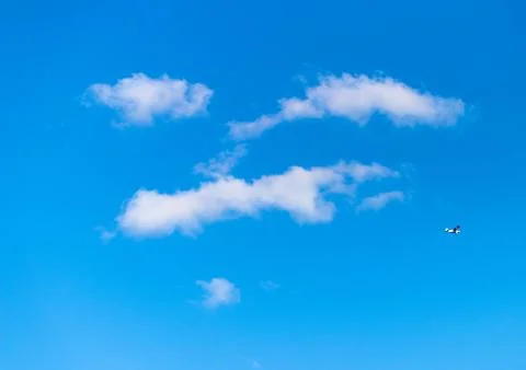 Blue sky with white fluffy face shaped clouds Stock Photos