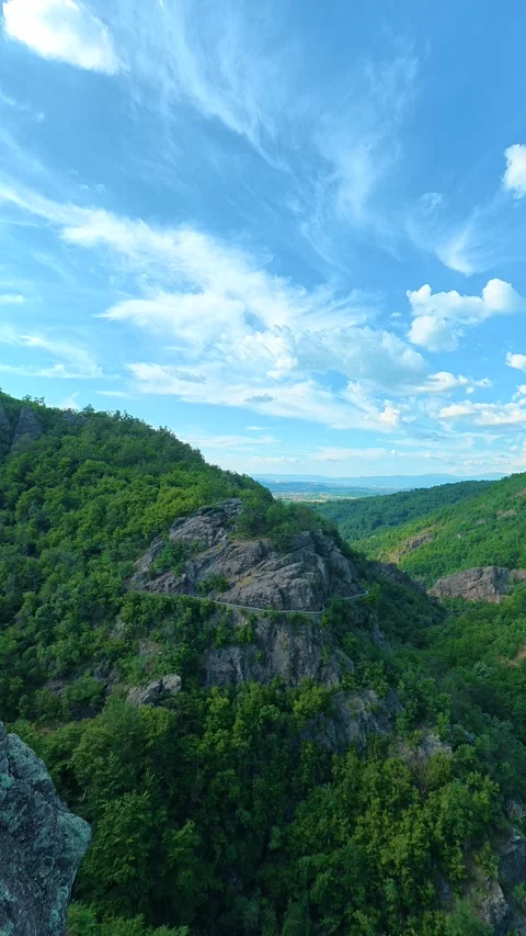 Blue sky with wispy clouds above rocky hills. Sokolica rock, Serbia. Vertical Stock Footage 341132791