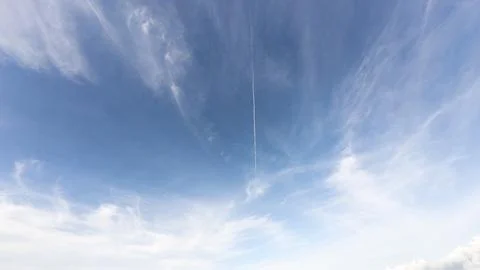 Blue Sky With Wispy Clouds and Jet Trail 스톡 사진