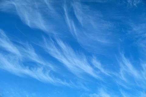 Blue sky with wispy white cirrus clouds. Clear weather backdrop with high a.. Stock Photos