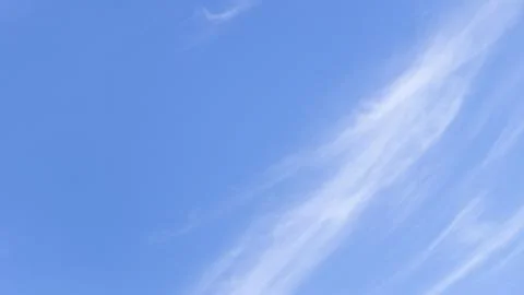 Blue Sky With Wispy White Cloud Background Фото