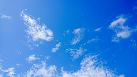 Blue sky with wispy white clouds. Stock Photos