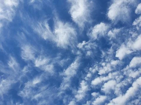 Blue Sky With Wispy White Clouds Overhead Serene Airy Background For Design.. Фото