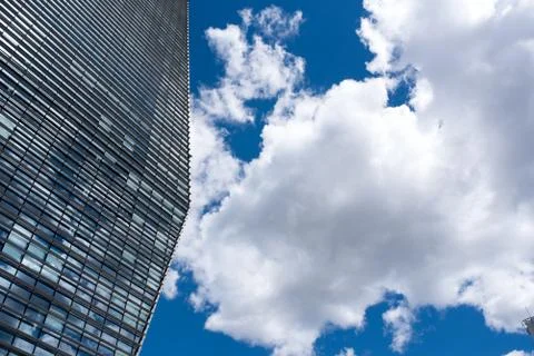 Blue skyscraper with reflections of clouds on windows Stock Photos