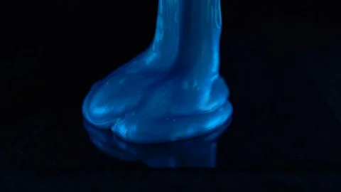 Blue slime oozing onto glas infront of black background Video stock 127342980