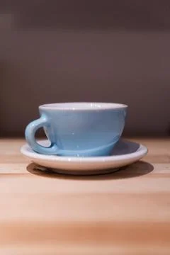Blue small cup on the table. Image contains excessive noise Stock Photos