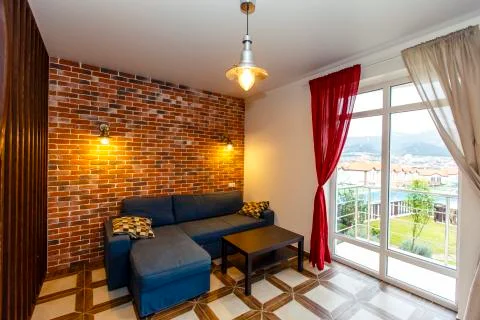 A blue sofa with a coffee table in the back of the cottage. Behind the sofa i Stock Photos