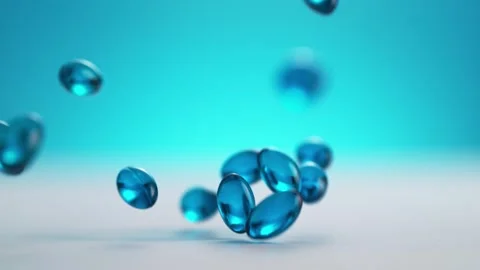 Blue Softgel Capsules Falling on a White Clean Table. Stock Footage 271006575