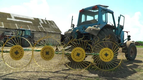 On a blue Soviet tractor are a rake of tedders and swaths Stock Footage 119495754