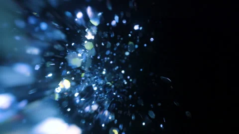 Blue sparkle glitter falls into frame and disappears into black in slow motion Stock Footage 153917791