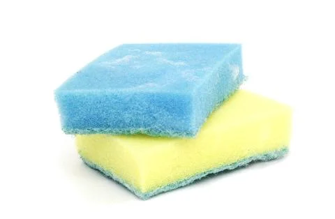 A blue sponge with foam cleaning solution and a new yellow sponge under it .. Fotos de archivo