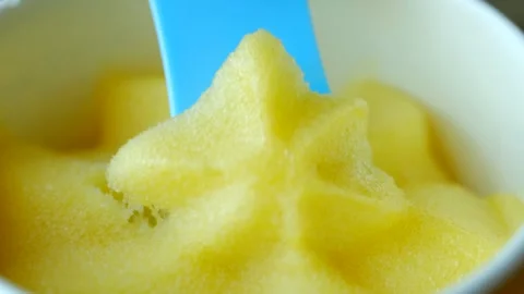 Blue spoon scooping delicious yellow ice cream Stock Footage 310521633
