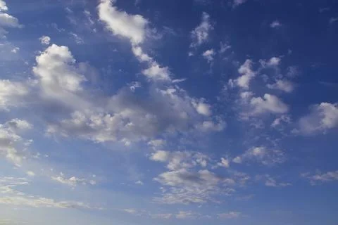 The blue spring sky is covered with light white cirrostratus clouds. Stock Photos