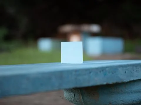 Blue square note card standing on outdoor table Stock Photos