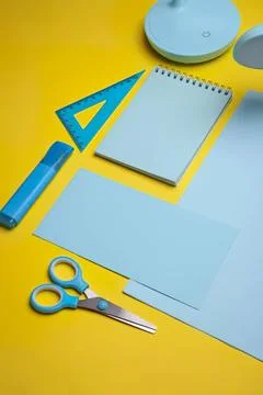 Blue stationery set with notepad scissors and ruler on yellow background Stock Photos