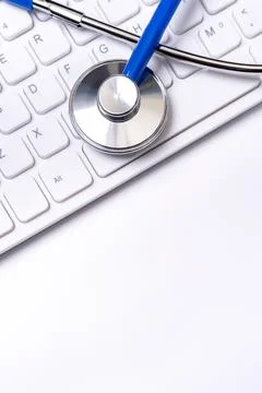 Blue stethoscope on computer keyboard on white table background. Online medic Photos