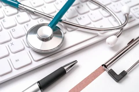 Blue stethoscope on computer keyboard on white table background. Online medic Foto stock
