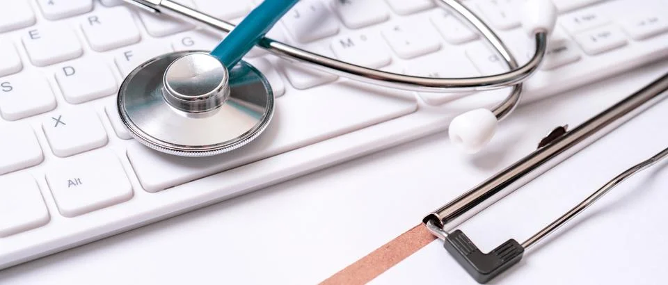 Blue stethoscope on computer keyboard on white table background. Online med.. Stock Photos