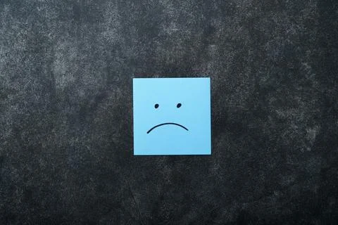 Blue sticky notes blank with drawing sad face on black background with copy.. Foto stock