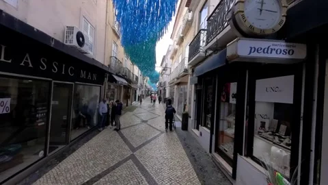 Blue streamer artwork over narrow cobblestone lane in Setubal, Portugal Vídeo Stock 273536426