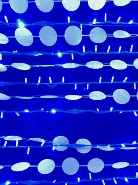 Blue string lights and circular hanging decorations form a striking backdro.. Foto stock