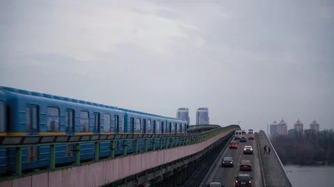 The blue subway train leaves the ground station on the bridge across the wide Stock Footage 122076624