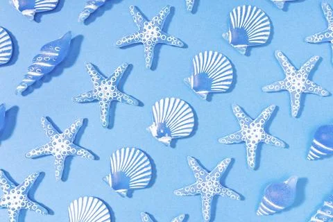 Blue summer background of a pattern of decorative glass sea conch. Starfish, sea Stock Photos