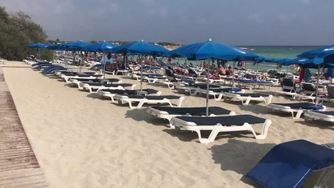 Blue Sun Beds and Umbrellas on a Windy Beach, Ayia Napa, Cyprus Stock Footage 101247727