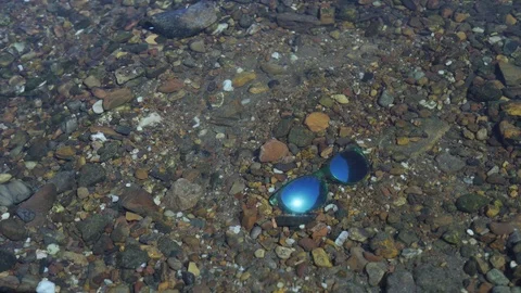 Blue sunglasses at a river bed Stock Footage 93733515