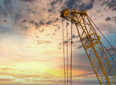 Blue sunset sky after five big high cranes under a new construction site of h Stock Photos