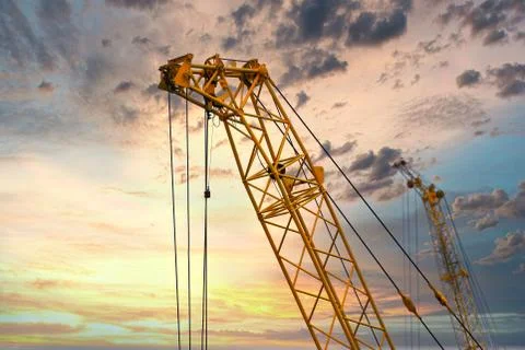 Blue sunset sky after five big high cranes under a new construction site of h Stock-Fotos