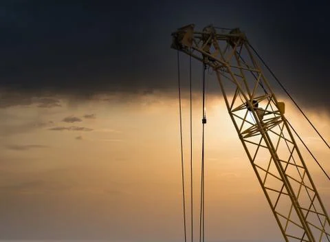 Blue sunset sky after five big high cranes under a new construction site of h 库存照片