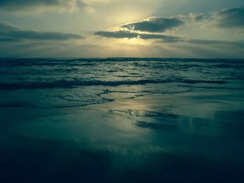 Blue sunset under a cloudy sky on a sandy beach 写真素材