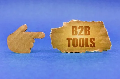 On a blue surface, a cardboard hand points to a sign with the inscription - B Stock Photos
