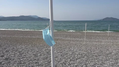 Blue surgical mask left on the empty beach during Coronavirus pandemia Stock Footage 127055098