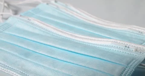 Blue Surgical Mask on White surface, isolated. Protection from airborne disease Stock Footage 147948662