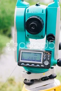Blue surveying equipment total station on a background of lake and forest Stock Photos
