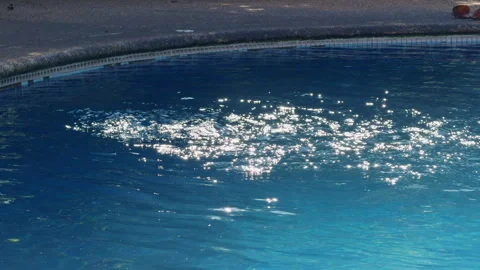 Blue Swimming Pool Water With Bright Sun Sparkles and Gentle Ripples Creating Ca Vidéo 330130952