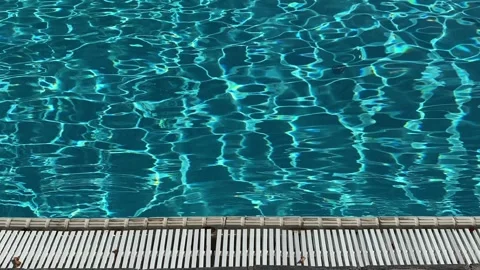 Blue swimming pool water surface with sunlight reflections. 4K Stock Footage 341840595