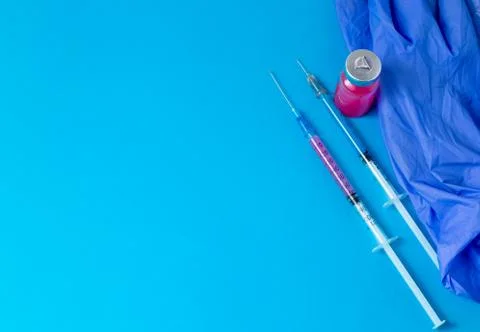 On a blue table are two insulin syringes filled with a drug of different colo Stock Photos