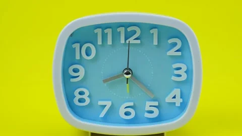 ฺฺBlue table clock on yellow background. Stock Footage 230114618