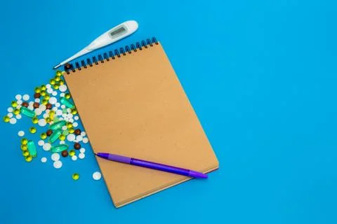 On a blue table is a notebook of their natural material for recording, and ne Stock Photos