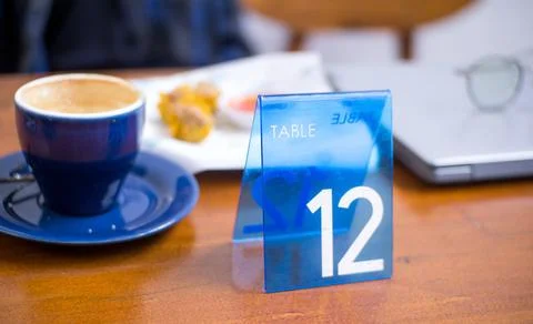 Blue Table Number 12 Tag on Wooden Restaurant Table Stock Photos