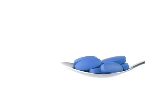 Blue tablet on the spoon Stock Photos