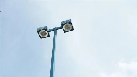 Blue tall light post with two turned off circle pot light in squares opposite Stock-Footage 250277140