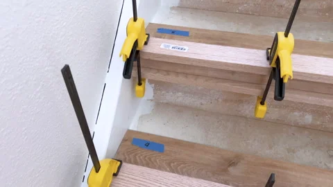 Blue tape markers on stair risers during remodel Stock Footage 313681878